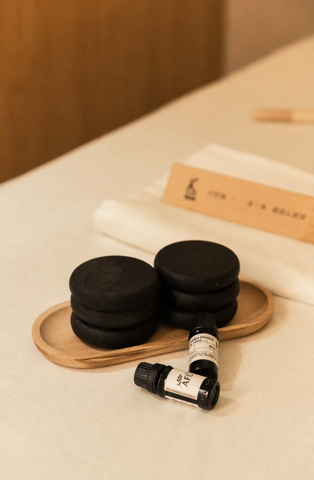 服务床面上的热石、毛巾与阿芙精油瓶